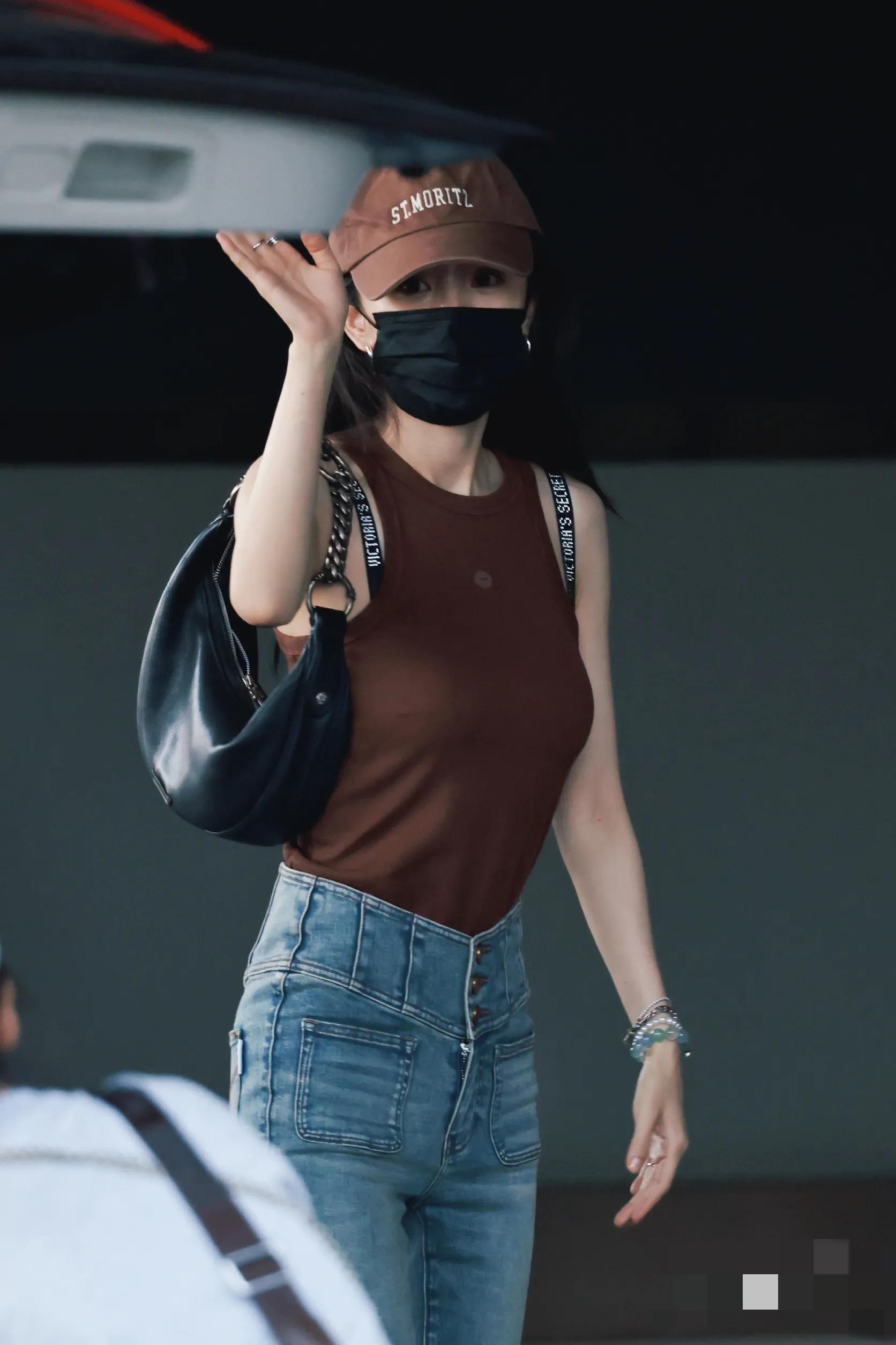 杨幂长沙路透，身穿砖红色背心搭配牛仔喇叭裤，腰肢纤细身高腿长