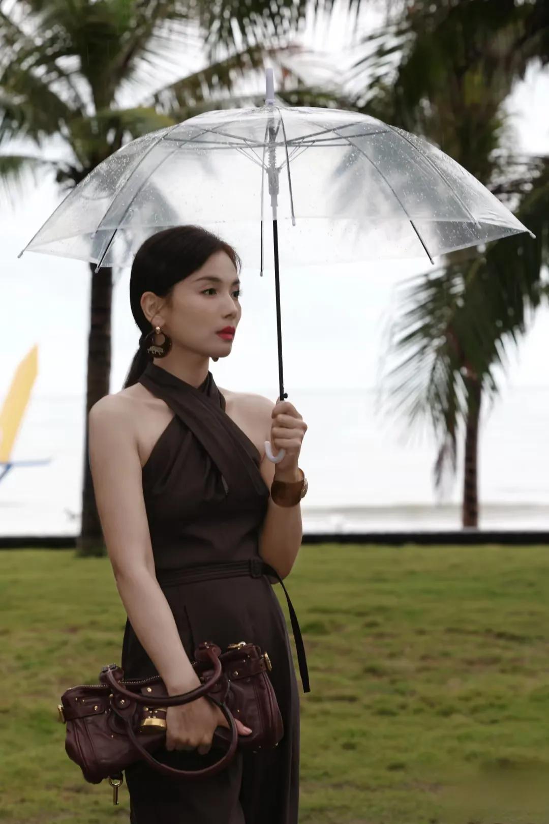 刘涛分享美照,深棕挂脖连身裤配低马尾,雨中持伞尽显优雅酷飒