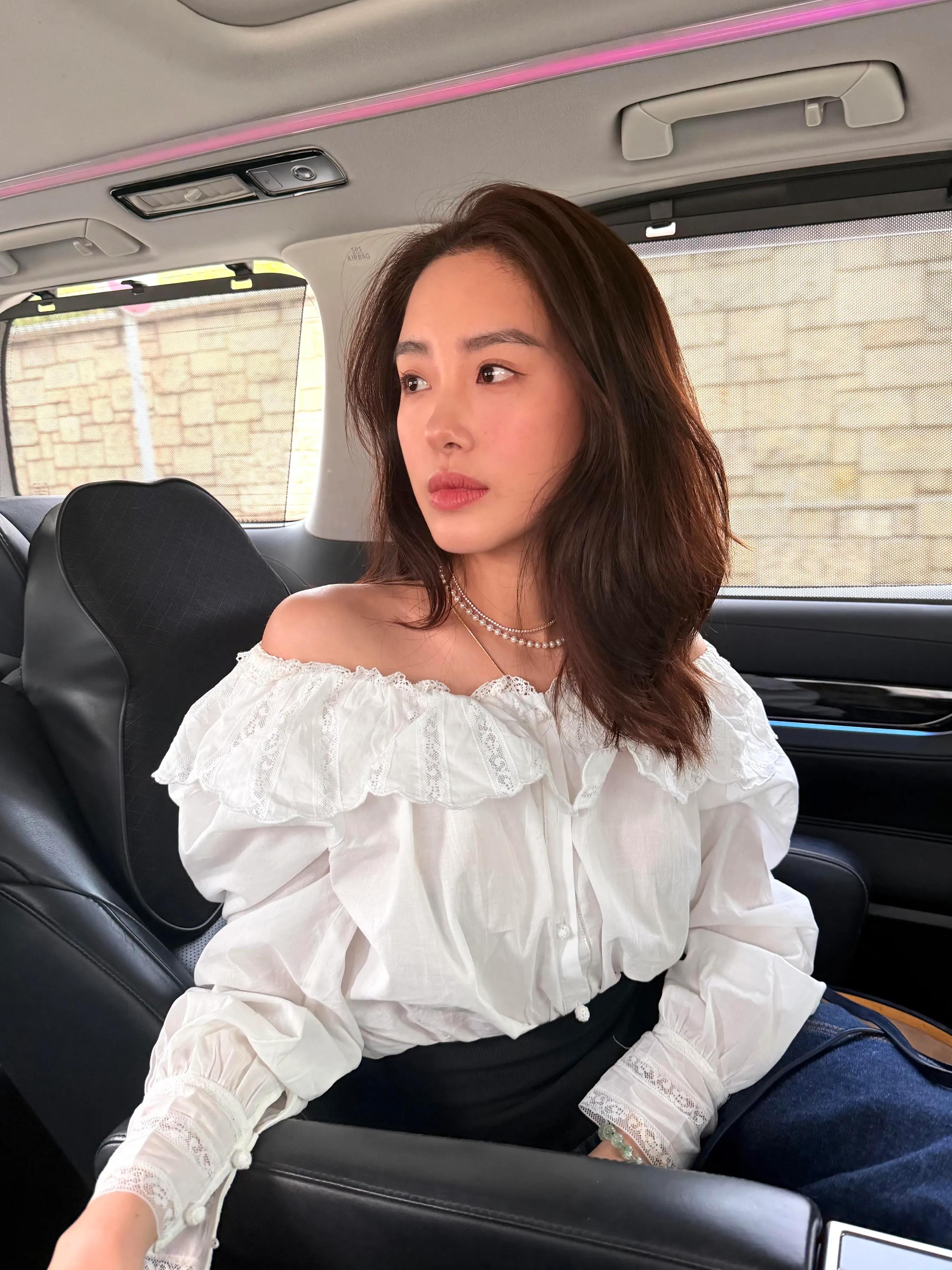 杨采钰在香港看艺术展，她脖子上挂着叉子，她穿了一万五的牛仔裤