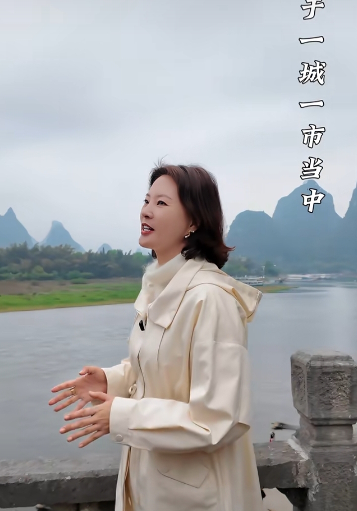 刘芳菲穿米白风衣现身阳朔，简约穿搭尽显知性优雅之美