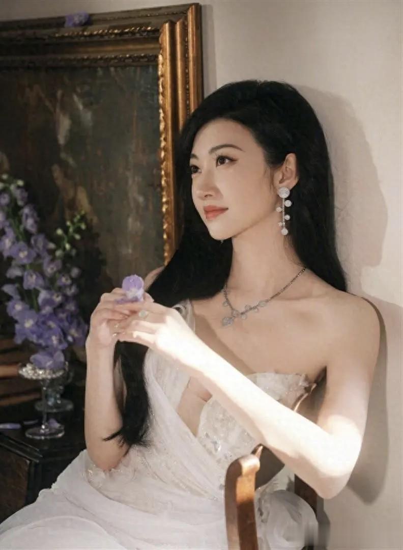 景甜一袭白色薄纱裙在阳光下写真，明媚动人。