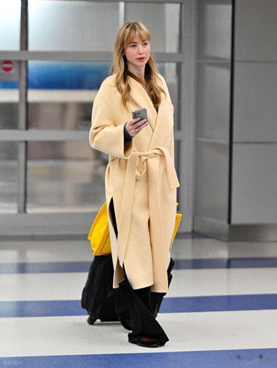 “大表姐”詹妮弗·劳伦斯现身肯尼迪机场,身穿浴袍大衣时尚大气