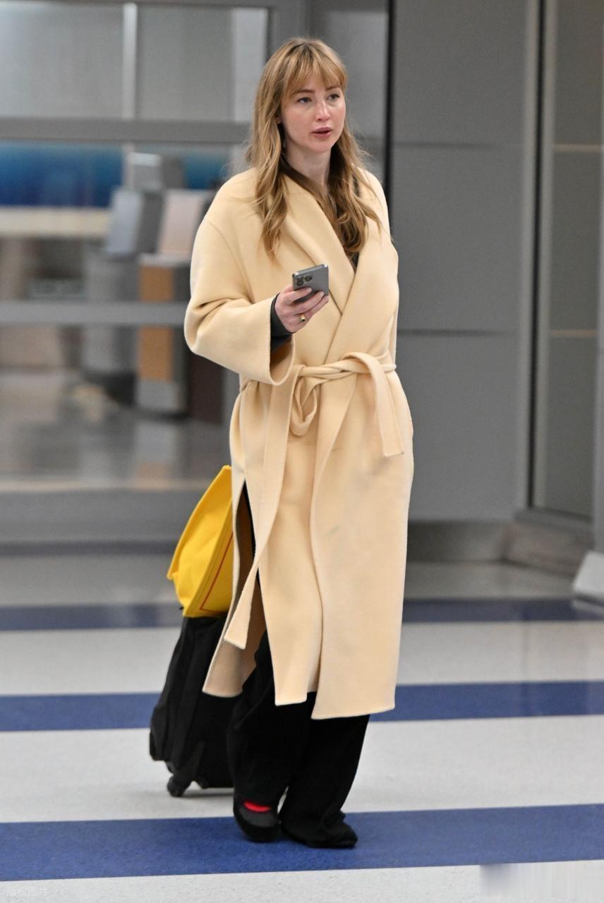 “大表姐”詹妮弗·劳伦斯现身肯尼迪机场,身穿浴袍大衣时尚大气