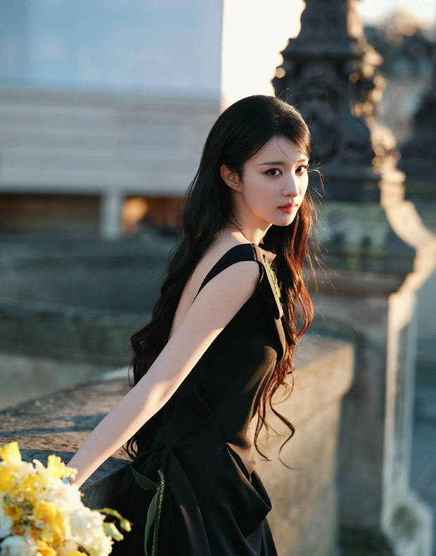 王楚然穿黑色立体花饰露背裙 在桥边漫步裙摆轻扬
