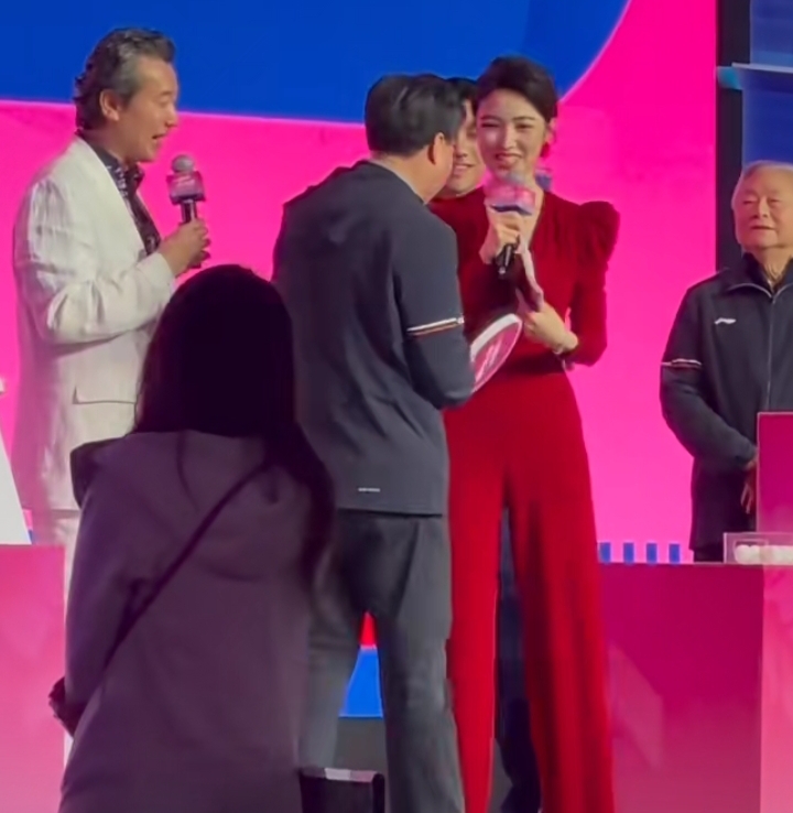 何卿主持乒乓嘉年华，红深V长裙配盘发，明艳优雅惊艳