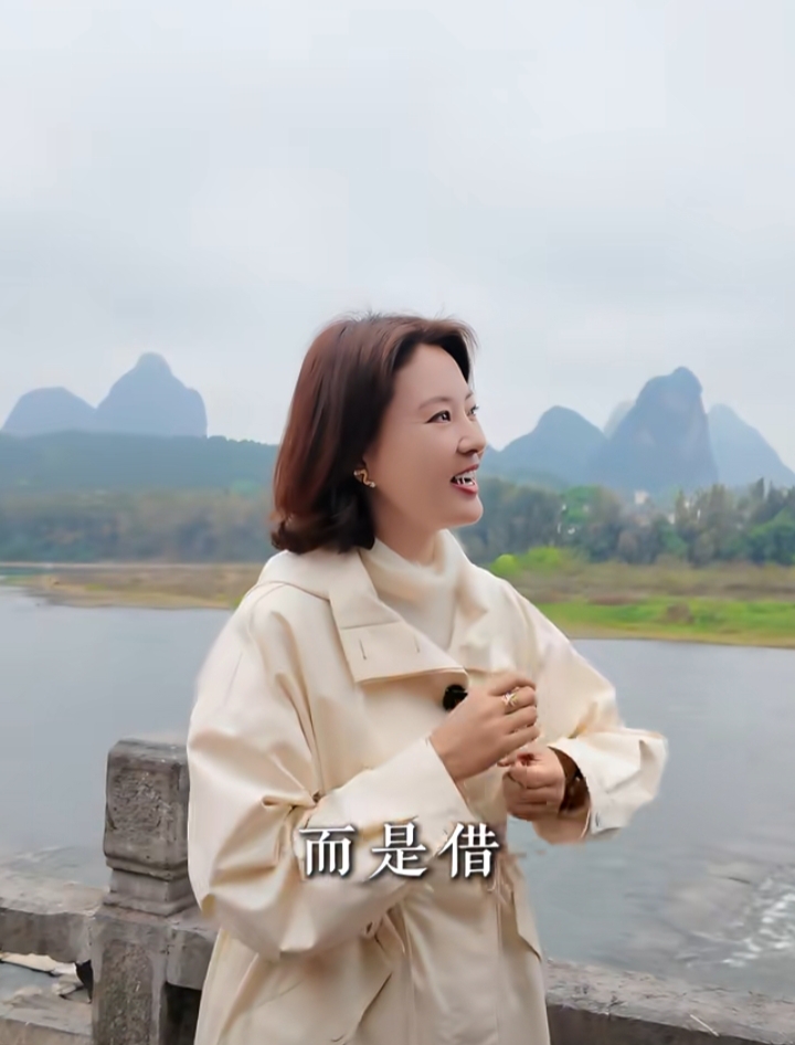 刘芳菲穿米白风衣现身阳朔，简约穿搭尽显知性优雅之美