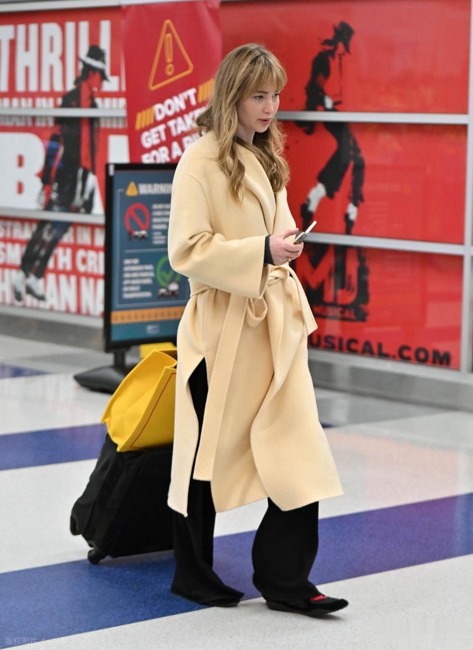 “大表姐”詹妮弗·劳伦斯现身肯尼迪机场,身穿浴袍大衣时尚大气