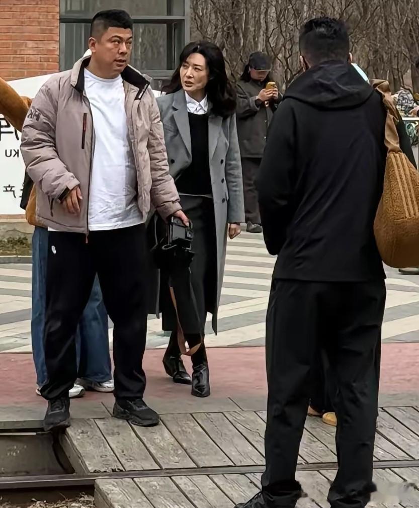 58岁周涛在北京朗园游玩，穿长筒靴和灰大衣，一头长卷发气质非凡