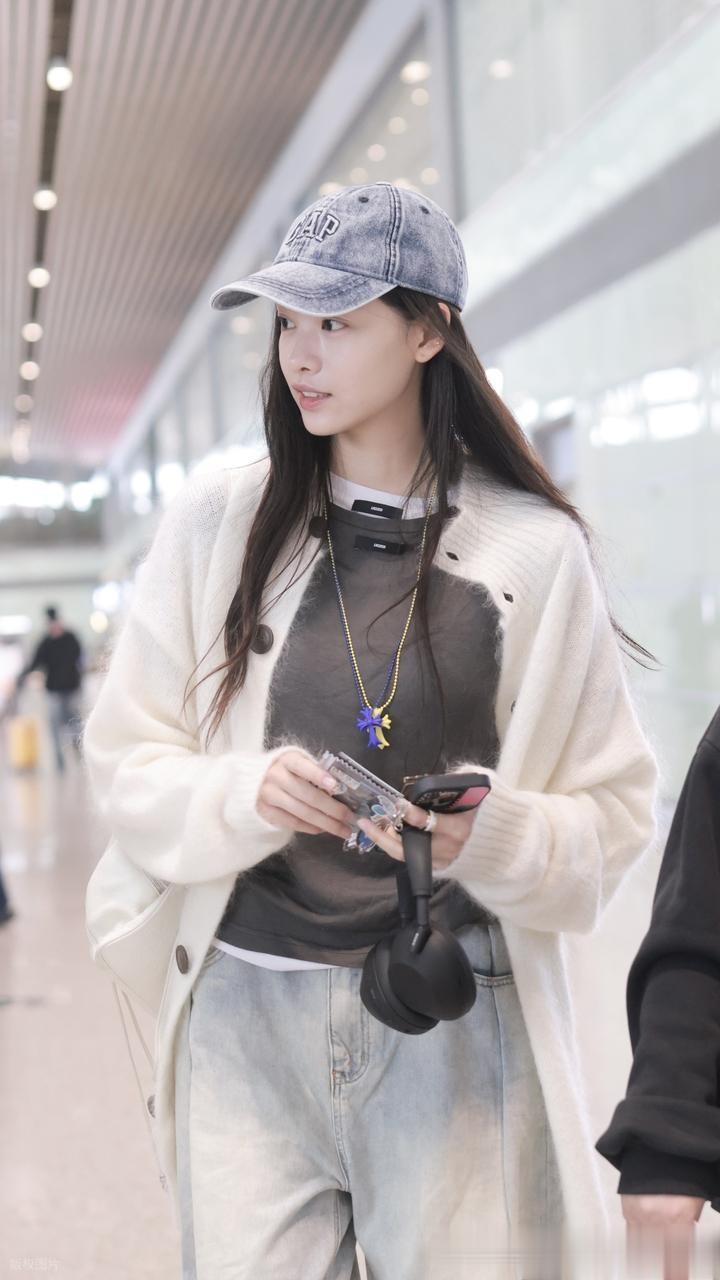张艺上身穿白色针织外套内搭配深灰色打底牛仔裤现身机场