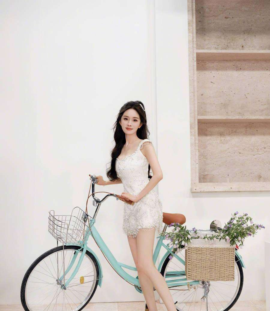 杨幂身穿珍珠流苏连衣裙化身单车少女俏皮灵动