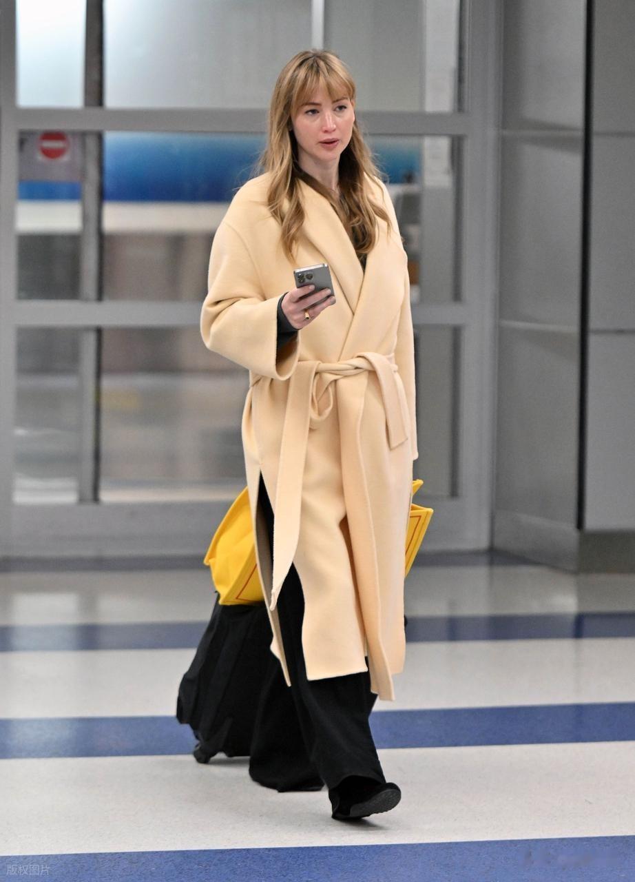 “大表姐”詹妮弗·劳伦斯现身肯尼迪机场,身穿浴袍大衣时尚大气
