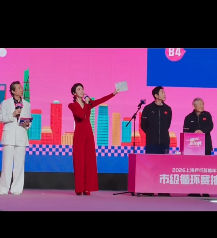 何卿主持乒乓嘉年华，红深V长裙配盘发，明艳优雅惊艳