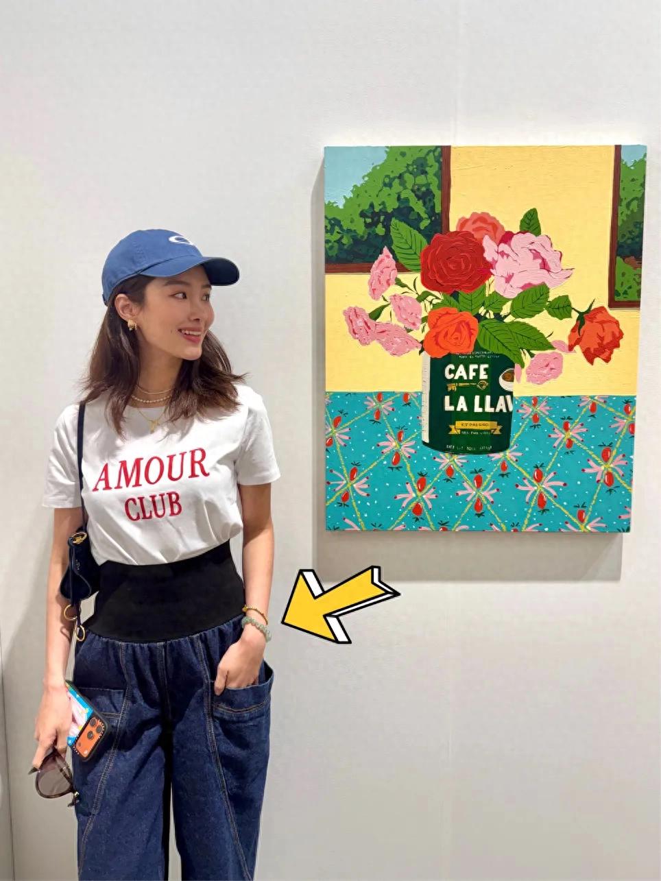 杨采钰在香港看艺术展，她脖子上挂着叉子，她穿了一万五的牛仔裤
