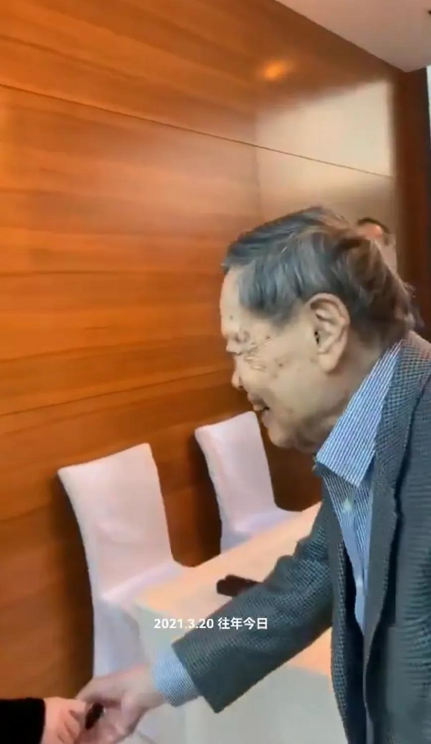 翁帆在香港参加春茗，她穿白色大衣很美，她写完毛笔字害羞的笑了